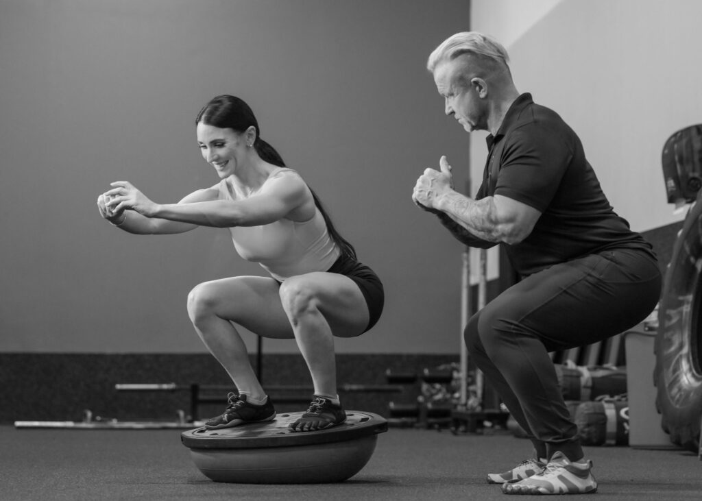 Personal trainer coaching a client through a squat at Bodystyle Fitness in Clearwater FL